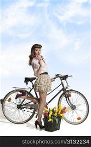 sexy fashion female with vintage style on bicycle with colourful flowers in basket. Wearing pink shirt, heels and short skirt