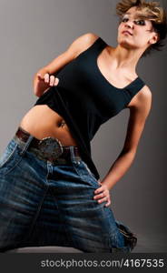 sexy fashionable knelt down woman wearing black tank top and jeans