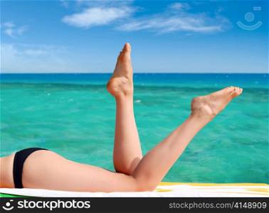 sexy female legs against the turquoise sea background