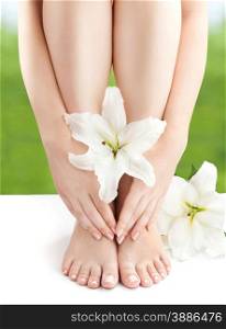 Sexy Female Naked Feet and Hands with French Pedicure and Manicure with White Lily.