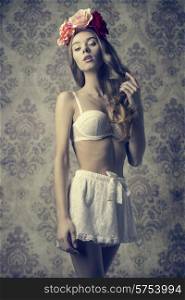 sexy female with romantic style wearing white vintage lingerie and spring colorful flowers on the head. Long natural wavy hair