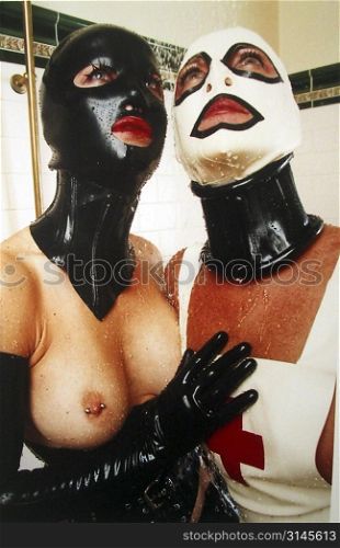 Sexy fetish play, two women lust after eachother in the shower dressed in latex and rubber.