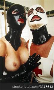 Sexy fetish play, two women lust after eachother in the shower dressed in latex and rubber.