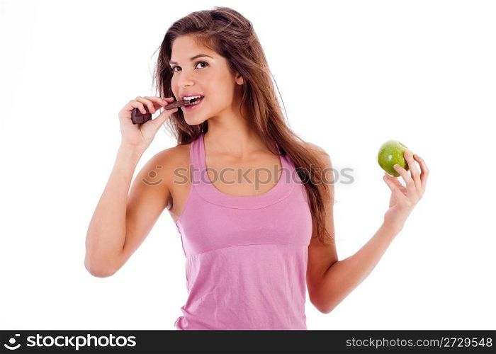 sexy girl biting a chocklate and keep the apple in other hand