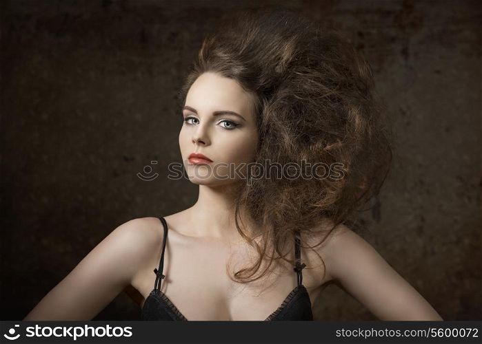 sexy girl with charming expression wearing black bra and posing with voluminous creative hair-style