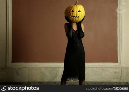 Sexy lady with big pumpkin on head. Surrealstic portrait.