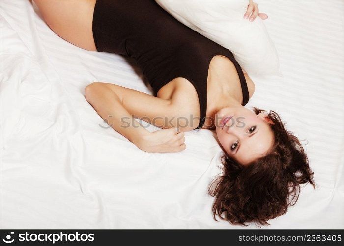 Sexy lazy girl in black body lying on the bed. Young attractive woman relaxing lazing in her bedroom at the morning.