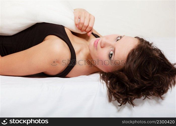 Sexy lazy girl in black body lying with pillow on the bed. Young attractive woman relaxing lazing in bedroom at morning.