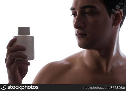 Sexy man with bottle of perfume in low key photo