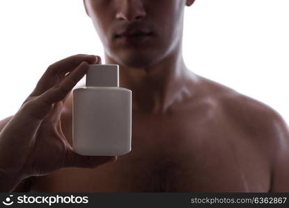 Sexy man with bottle of perfume in low key photo