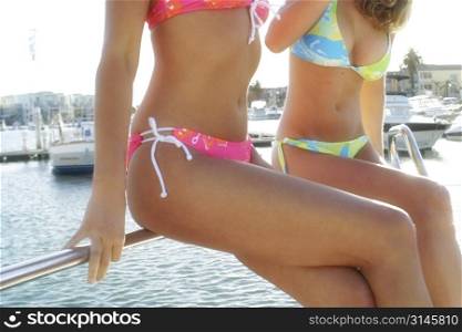 Sexy models pose in Bikinis by the water.