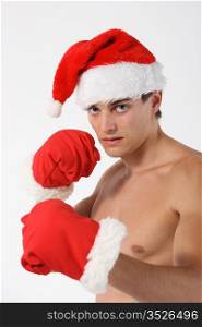 Sexy muscular man boxer wearing a Santa Claus hat isolated on grey