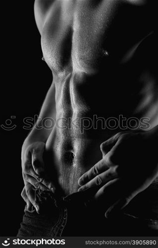 Sexy muscular naked man with water drops on stomach