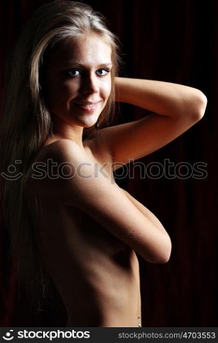 Sexy naked young woman in dark studio
