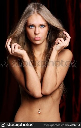 Sexy naked young woman in dark studio