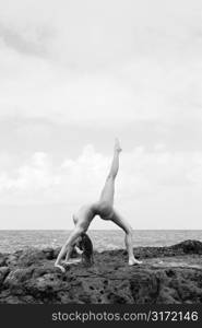 Sexy nude Caucasian woman doing backbend on beach in Maui, Hawaii.