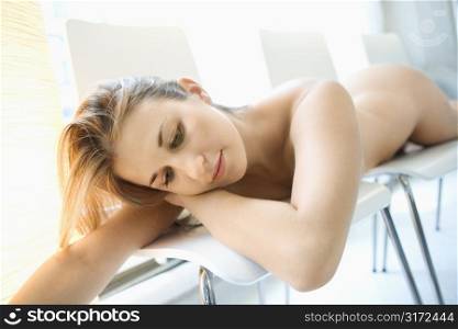 Sexy nude Caucasian young adult woman lying seductively.