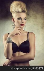 sexy portrait of charming young girl posing with aristocratic expression, creative hair-style and lingerie. Wearing black bra and glossy jewelleries