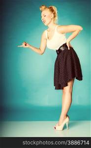 Sexy retro girl full length. Pin up woman with blonde hairdo and finger gesture sign in studio. Vintage photo.