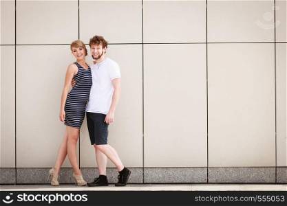 Sexy sensual couple posing outdoor. Pretty stunning woman in striped dress and handsome man in white shirt. Love and date concept.
