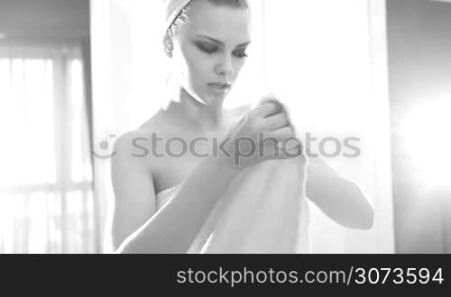 sexy woman after shower looking at the window wearing towels