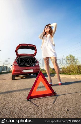 Sexy woman calling mechanic after car breakdown