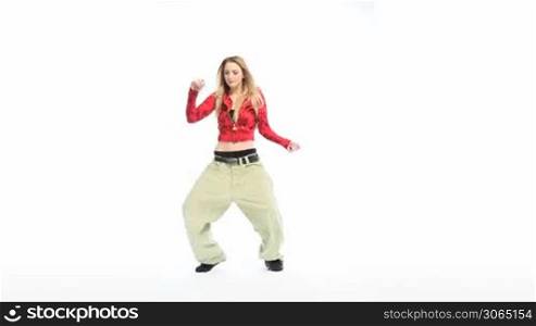 Sexy woman hip hop dancer posing with one arm raised and the other on her hip, full body facing camera.