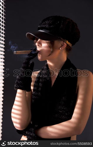 sexy woman in black astrakhan smoking cigar