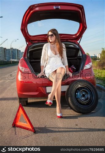 Sexy woman in short dress waiting for help near broken car