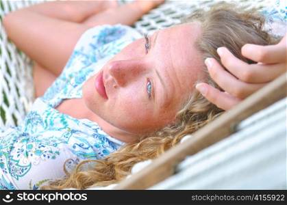 sexy woman is lying in hammock and looking sideways