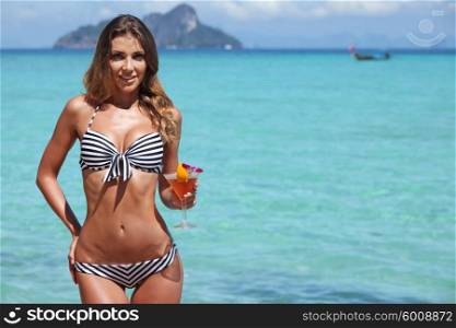 Sexy woman on beach. Sexy woman in bikini with cocktail on beach in Thailand
