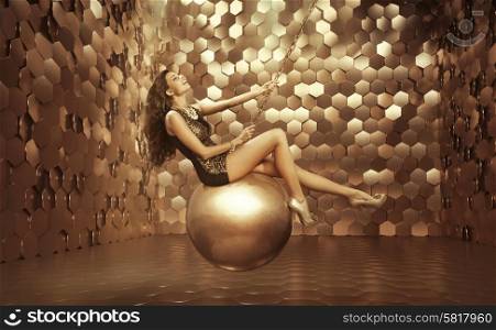Sexy woman on the big golden ball