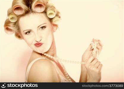 Sexy woman preparing to party having fun, girl in underwear curlers in hair with beads pink background