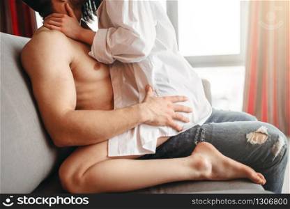 Sexy woman sitting on man, intimate games on couch, passionate lovers. Sexy love couple, intimacy at home. Sexy woman sitting on man, intimate games on couch