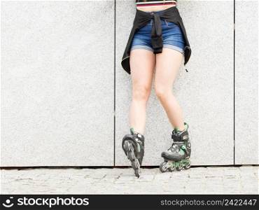 Sexy woman slim legs wearing roller skates standing outside. Sport activity concept.. Sexy woman wearing roller skates