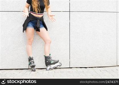 Sexy woman slim legs wearing roller skates standing outside. Sport activity concept.. Sexy woman wearing roller skates