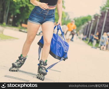 Sexy woman slim legs wearing roller skates standing outside. Sport activity concept.. Sexy woman wearing roller skates