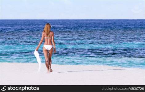 Sexy woman walking on the beach, back side, perfect body, luxury summer holidays on Maldives, travel and vacation concept&#xA;