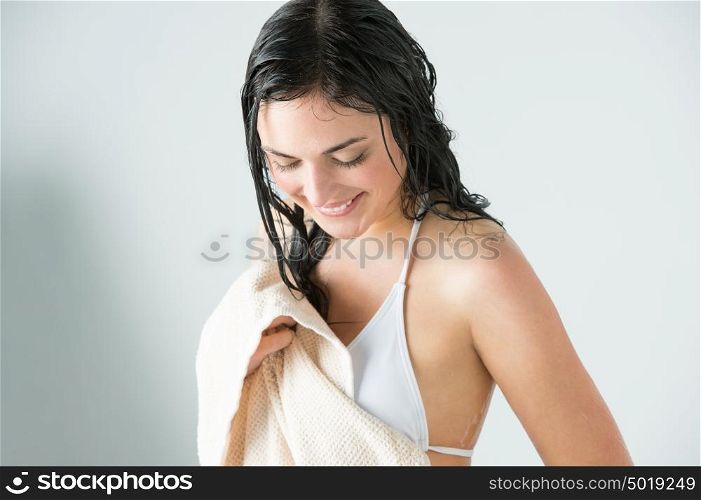 Sexy woman wiping herself with towel after taking shower at home and looking happy