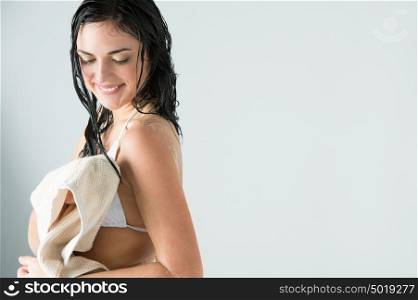 Sexy woman wiping herself with towel after taking shower at home and looking happy