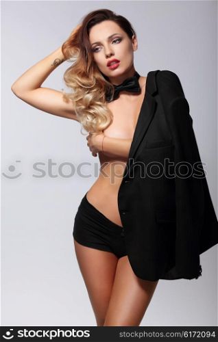 Sexy woman with a man&rsquo;s jacket posing in studio.