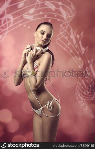 sexy woman with bikini listening music with headphones, in sensual pose