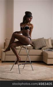 Sexy young african woman in lingerie with long hair posing at home