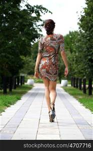 Sexy young brunette walking in summer park