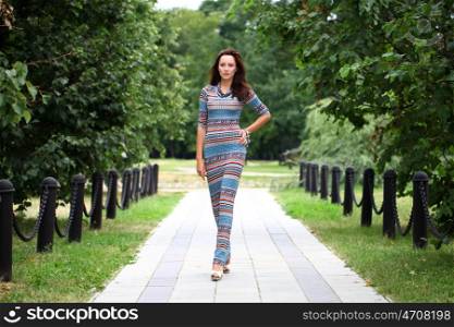 Sexy young brunette walking in summer park