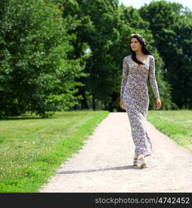 Sexy young brunette walking in summer park