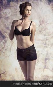 sexy young girl posing with cute make-up, elegant hair-style, wearing black shorts, in sensual pose