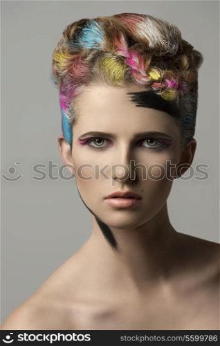 sexy young lady with charming expression posing in beauty shoot with multicolor painted hair-style and creative make-up