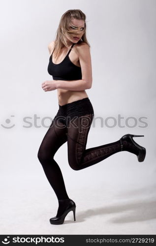 Sexy young model running over grey background