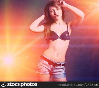Sexy young self- confident brunette girl dancing in discolight